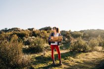 Corpo pieno di concentrato giovane esploratore femminile in abiti casual mappa di lettura mentre si cammina sul pendio della montagna nella giornata di sole — Foto stock