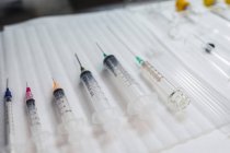 Composition of sterile medical syringes of different sizes arranged on table in hospital — Stock Photo