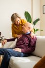 Positives Paar mittleren Alters, das Spaß im Wohnzimmer hat, während es Zeit zu Hause zusammen verbringt — Stockfoto