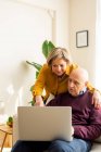 Alegre maduro casal falando no vídeo chat no laptop na sala de estar — Fotografia de Stock
