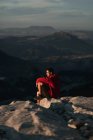 Vista lateral de caminhante masculino pensativo em desgaste casual descansando no cume da montanha rochosa e admirando vistas panorâmicas sobre terras altas ásperas em Sevilha Espanha — Fotografia de Stock