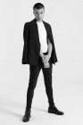 Modello maschile serio in abito alla moda in piedi su sfondo bianco in studio e guardando altrove — Foto stock