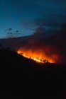 Foresta di campagna con cielo nuvoloso coperto da fumo di fuoco durante la sera — Foto stock
