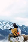 Side view female tourist with backpack using photo camera while shooting amazing nature of Peaks of Europe during trip — Stock Photo