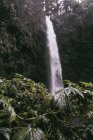 Increíble vista de la cascada de gran alcance que cae desde el áspero acantilado rígido en el parque tropical - foto de stock