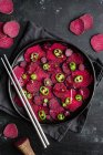 Top view composition of tasty beetroot slices arranged on baking pan with green jalapeno peppers and placed on black towel on kitchen table close to chopsticks — Stock Photo