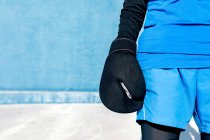 Anonimo allegra anziana femmina in activewear in guanti da boxe contro muro blu — Foto stock