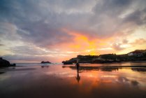 Невпізнаваний чоловік насолоджується заходом сонця біля моря в літній день — стокове фото