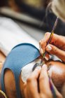 Crop unrecognizable cosmetologist with tweezers applying fake eyelashes for extension on eye of ethnic client with face protective mask in salon during coronavirus pandemic - foto de stock