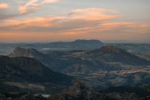 Vista panoramica di ampio terreno montuoso con piste coperte di verde sotto il cielo del tramonto a Siviglia Spagna — Foto stock