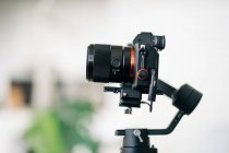 Современная цифровая фотокамера с циферблатом режима и видоискателем над дисплеем на размытом фоне — стоковое фото