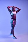 Muskulöse afroamerikanische Athletin mit verschwitztem Körper mit Bizeps auf blauem Hintergrund — Stockfoto