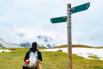 Back view of female backpacker standing against pole in Peak of Europe — Stock Photo