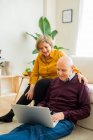 Cheerful mature couple talking on video chat on laptop in living room — Stock Photo