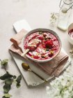 Сверху вкусный смузи со свежими ягодами и ледяными конфетками с дроблеными фисташками и йогуртом в миске — стоковое фото