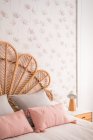 Confortável bonito natural vintage rattan cabeceira cama com almofadas ornamentais em um quarto — Fotografia de Stock
