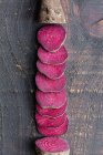 Zusammensetzung aus natürlicher biologischer Rote Bete in Scheiben geschnitten und auf schäbiger Holzoberfläche angeordnet — Stockfoto
