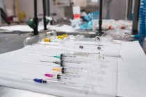 Composición de jeringas médicas estériles de diferentes tamaños dispuestas sobre la mesa en el hospital - foto de stock