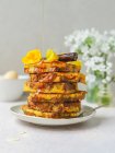 Pile of sweet French toasts being poured with honey served on plate for breakfast in kitchen — Stock Photo