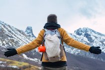 Back view of hiker with backpack and in warm clothes standing on rocky ridge of valley in Peaks of Europe and looking away — Stock Photo