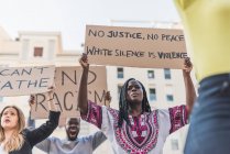 Низький кут афроамериканської жінки, яка протестує з плакатами під час чорного життя, створює демонстрації в місті. — стокове фото