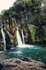Spektakulärer Blick auf mächtige Wasserfall fließt in See in bergigem Wald — Stockfoto