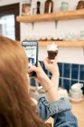 Ernte anonyme Frau fotografiert Cupcake mit Zuckerstreusel zu Hause — Stockfoto