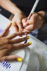 De dessus de la culture manucure méconnaissable faisant nail art pour cliente dans un salon de beauté à la lumière du jour — Photo de stock