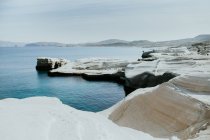 Vista panoramica di ruvida riva pietrosa vicino al mare blu increspato nella soleggiata Sarakiniko Grecia — Foto stock