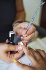 De cima de colheita irreconhecível manicure fazendo unha arte para cliente feminino no salão de beleza à luz do dia — Fotografia de Stock