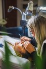 Female beauty master with tweezers applying fake eyelashes on face of ethnic client in salon - foto de stock