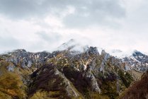 На мальовничих зелених полях із снігом у долині Піків Європи під важким хмарним небом в Іспанії. — стокове фото