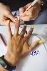 С вершины урожая неузнаваемый маникюрша делает ногти для клиента женского пола в салоне красоты при дневном свете — стоковое фото