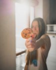 Giovane femmina con delizioso biscotto di farina d'avena con gocce di cioccolato a casa nella giornata di sole — Foto stock