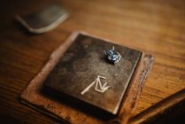 Gioiello blu lucido da primo piano per gioielli posizionato su piastra metallica su banco da lavoro in legno — Foto stock