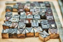 Set di lettere e numeri in metallo squallido letterpress collocati in scatola di legno in tipografia — Foto stock