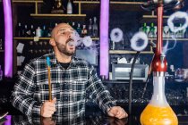 Mann raucht traditionelle Wasserpfeife in Nachtclub — Stockfoto