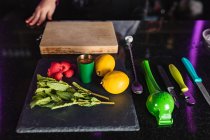 Hortelã-pimenta, limões, framboesa e utensílios em uma mesa de bar de preparações de coquetel — Fotografia de Stock