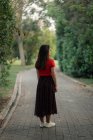 Модна жінка в літньому вбранні, стоячи на газоні в саду і дивлячись на камеру — стокове фото