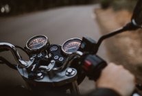 Pessoa cultura condução em motocicleta na rota de asfalto entre a floresta — Fotografia de Stock