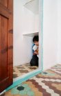 Unglücklicher verängstigter kleiner Junge mit Spielzeug versteckt sich in Kleiderschrank, während er unter häuslicher Gewalt leidet — Stockfoto