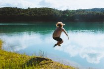 Unrecognizable man falling in lake on sunny day in dolomites in Italy — Stock Photo