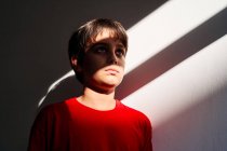 De baixo triste indefeso solitário pré-adolescente menino com hematomas no rosto sofrendo de violência doméstica — Fotografia de Stock