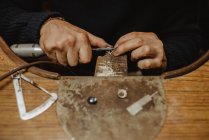 Joalheiro irreconhecível usando máquina de polimento profissional na bancada enquanto faz anel de metal na oficina — Fotografia de Stock