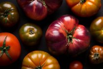 D'en haut différentes tomates fraîches sur une table noire — Photo de stock