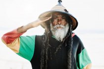 Porträt des alten Rastafari mit Dreadlocks, der in die Kamera blickt, in der Natur mit weißem Hintergrund — Stockfoto