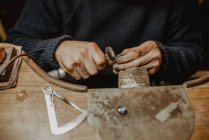 Juwelier mit professioneller Poliermaschine auf Werkbank bei der Herstellung von Metallringen in der Werkstatt — Stockfoto