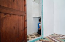 Несчастный испуганный мальчик с игрушкой, прячущимся в шкафу, страдая от домашнего насилия — стоковое фото