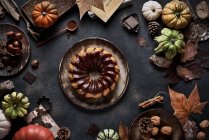 De cima bolo de abóbora apetitoso saboroso com nata de chocolate na mesa decorada com verduras de outono — Fotografia de Stock