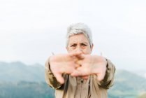 Мягкий фокус пожилых женщин-путешественниц, протягивающих руки и согревающих руки во время путешествия по холмистой местности — стоковое фото